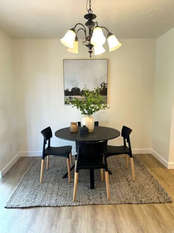Recessed lighting, wood-finish flooring, and a chandelier with frosted glass shades
