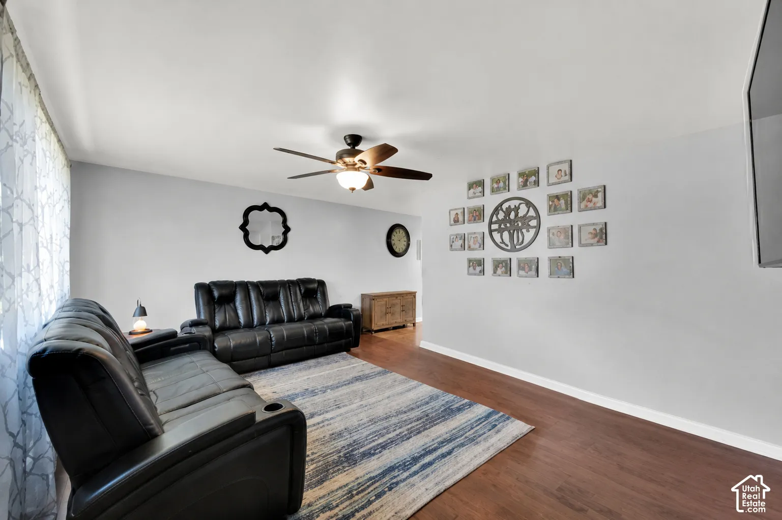 Wood-finish flooring throughout, ceiling fan with integrated lighting, and neutral wall tones