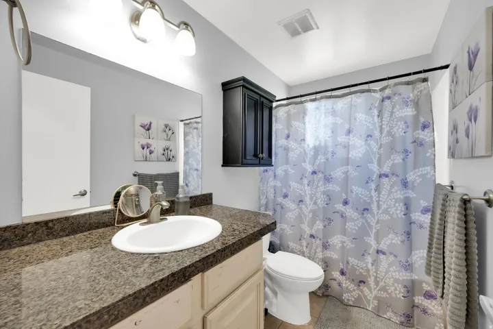 Vanity with integrated sink, expansive mirror, and brushed nickel fixtures