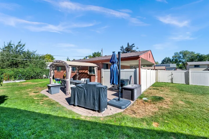 Paver patio featuring a pergola, brick exterior, and a privacy fence