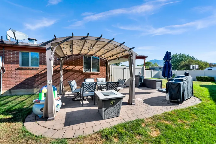 Patio featuring a paved surface, a pergola, and a brick exterior