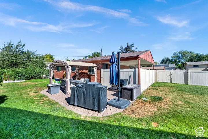 Paver patio featuring a pergola, brick exterior, and a privacy fence