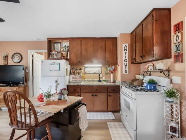 Wood-finish flooring, white appliances, and wood cabinetry