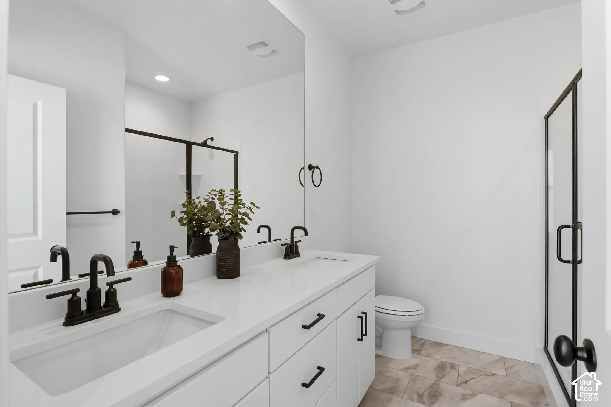 Dual vanity with white cabinetry, quartz countertop, and matte black fixtures