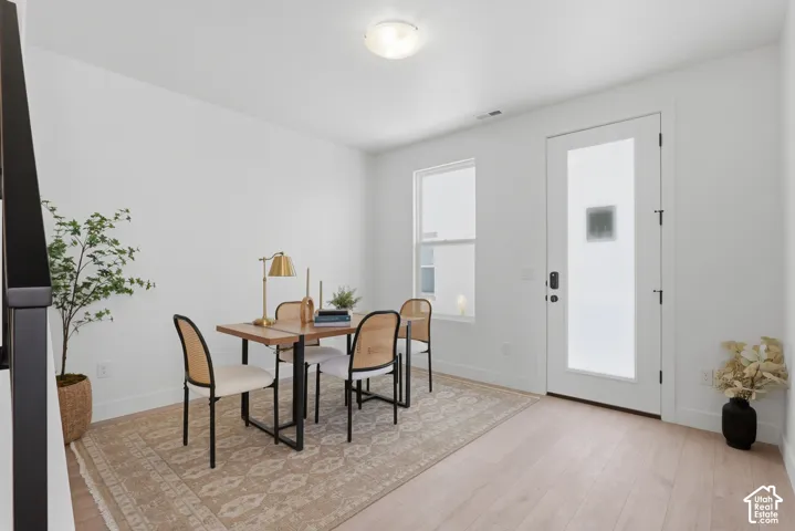 Light-toned wood-finish flooring, white walls, and a recessed ceiling light fixture