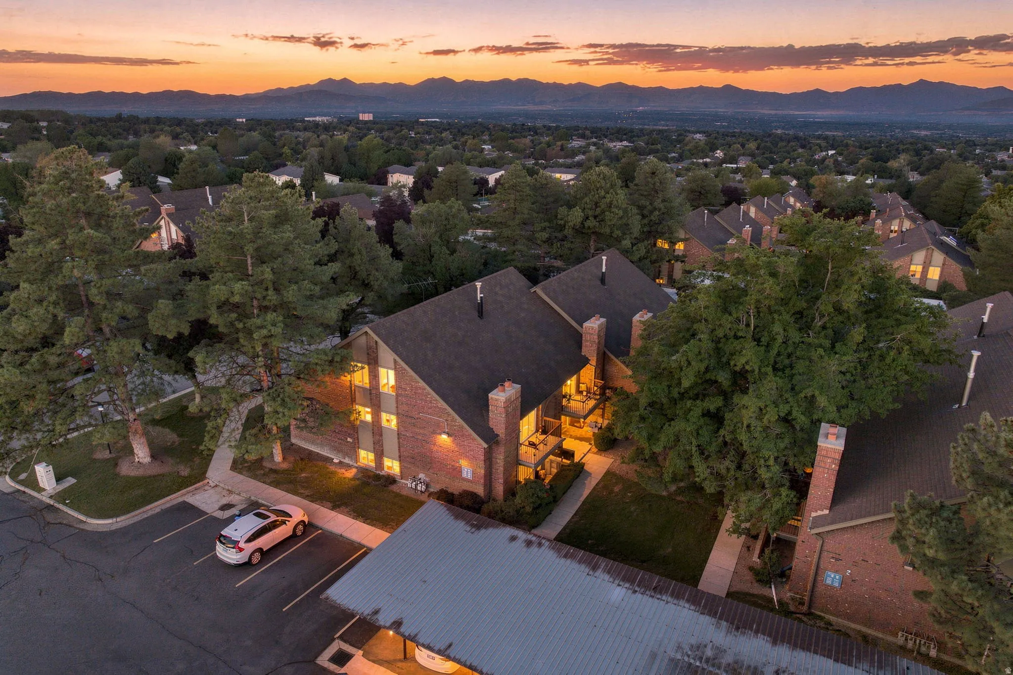Brick exterior construction featuring multiple levels, dark shingle roofing, and balconies