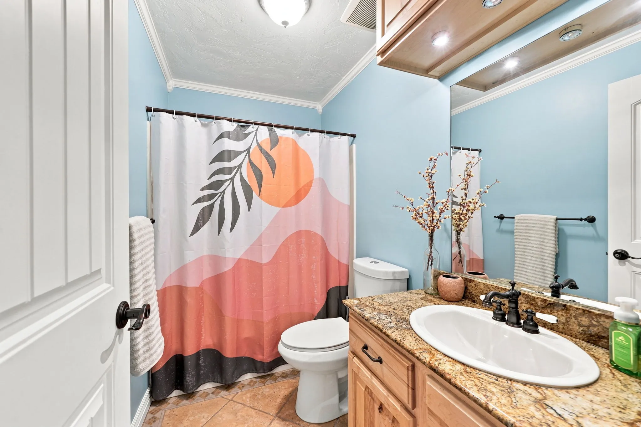 Vanity with an oval undermount sink, bronze-finish faucet, and granite countertop