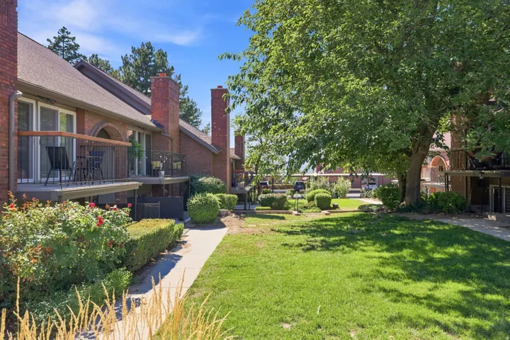 Brick exterior with multiple private balconies, featuring metal railings and wood-finish handrails