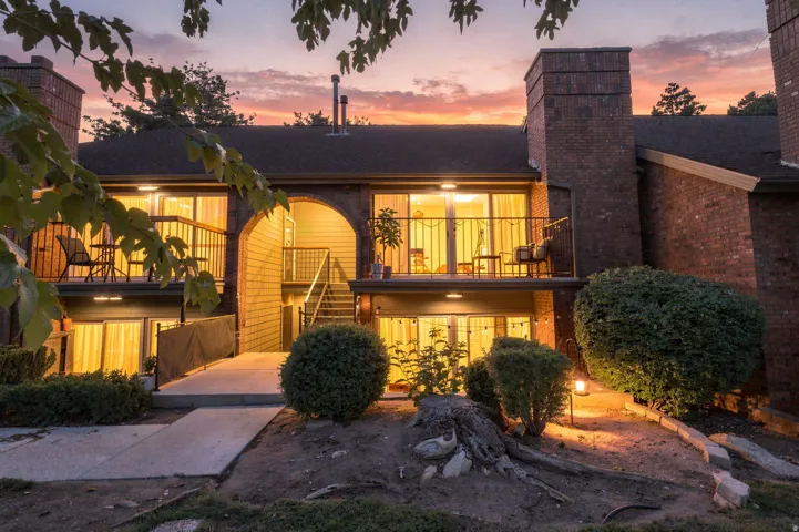 Brick exterior with multiple balconies, private entrances, and mature landscaping