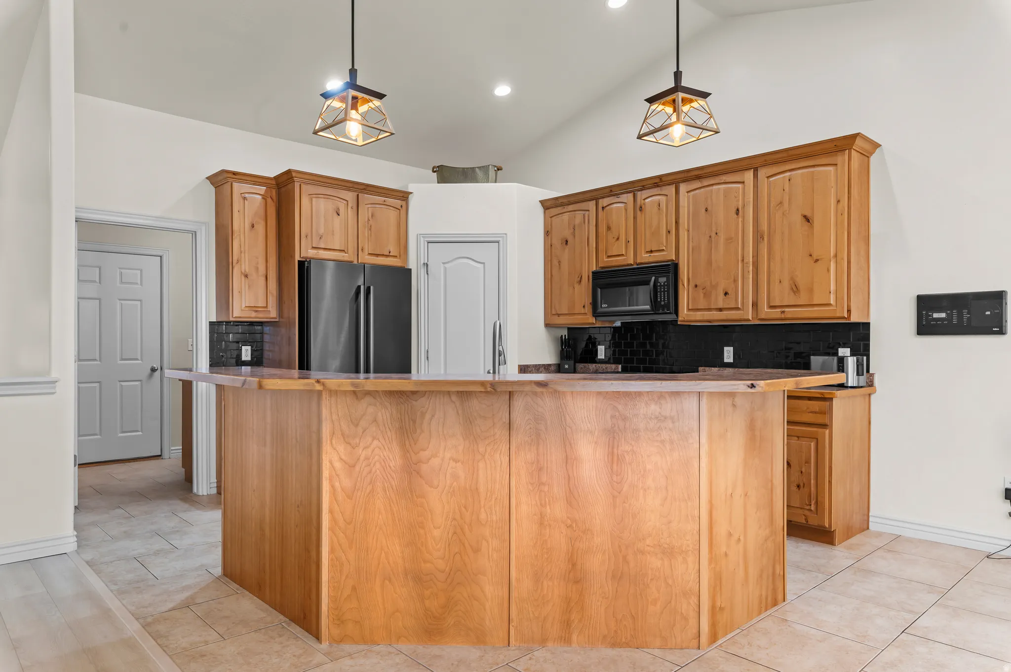 Vaulted ceiling with recessed lighting and two pendant fixtures