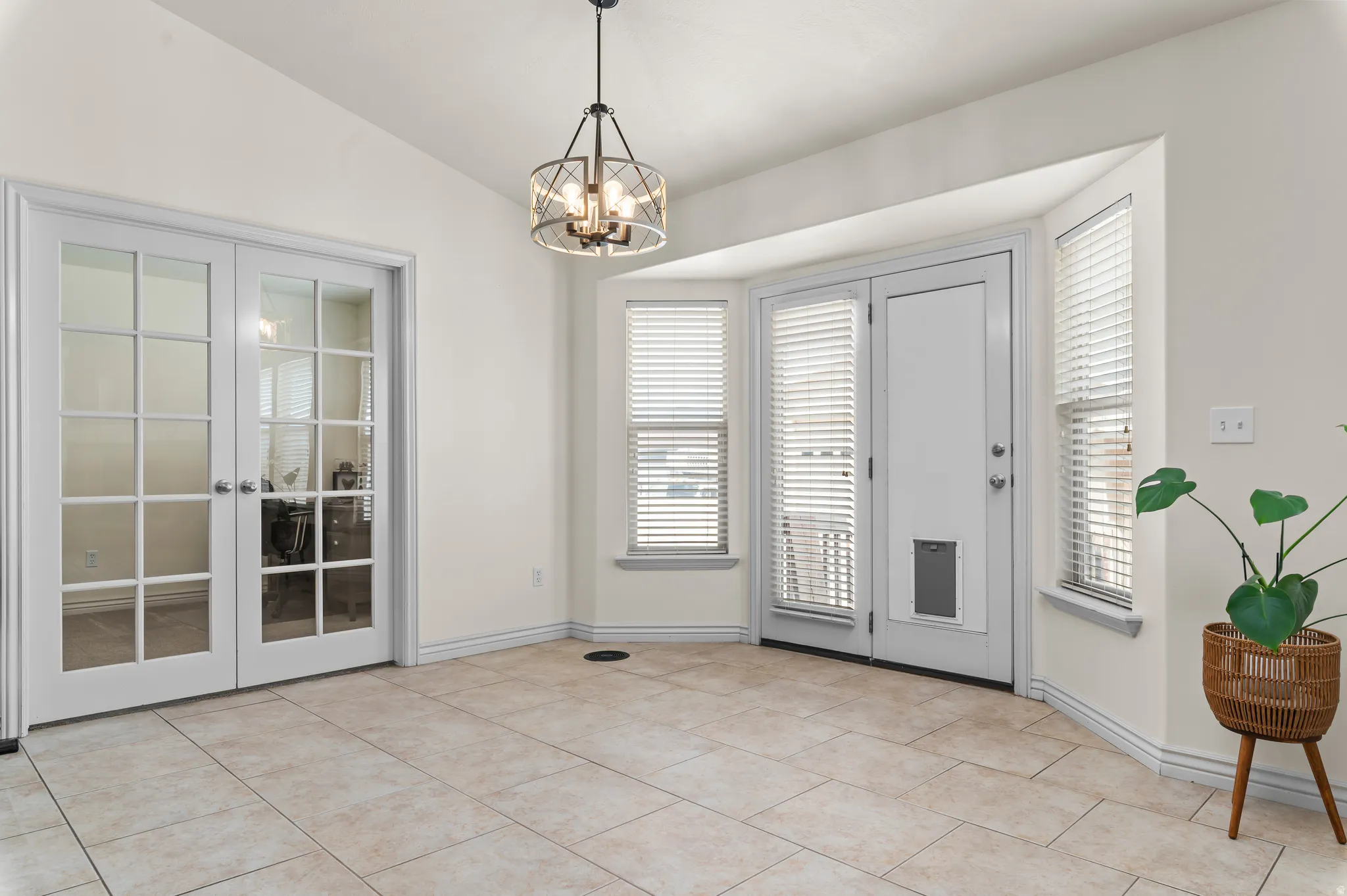 Bay window with multiple windows, glass-panel french doors, and a decorative ceiling light fixture