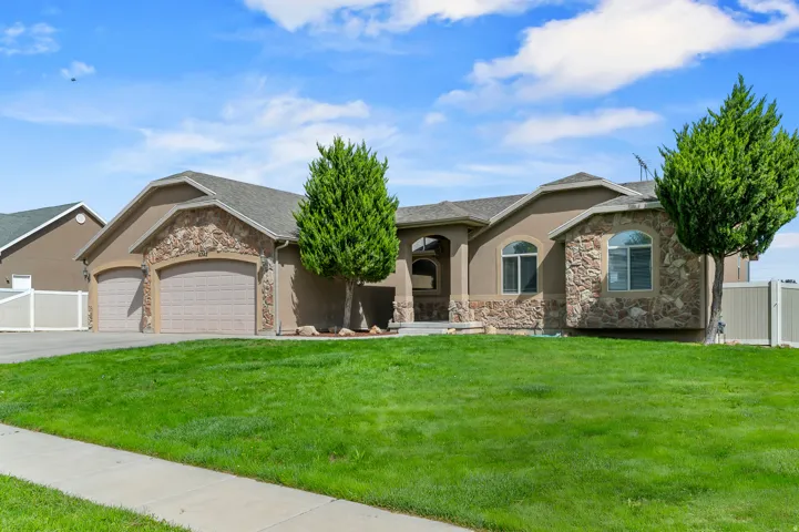 Stucco exterior with stone accents, arched windows, and a four-car garage