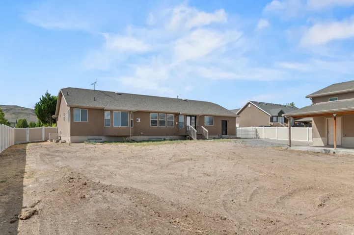 Expansive rear yard with a covered patio area and partial fencing