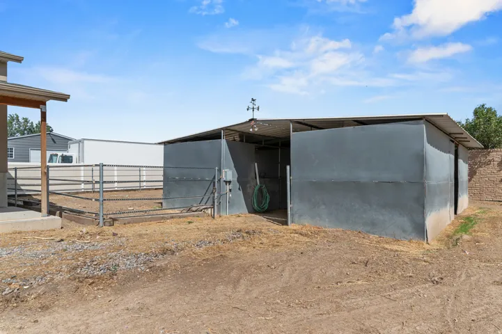 Metal-sided barn structure with an open-faced stall