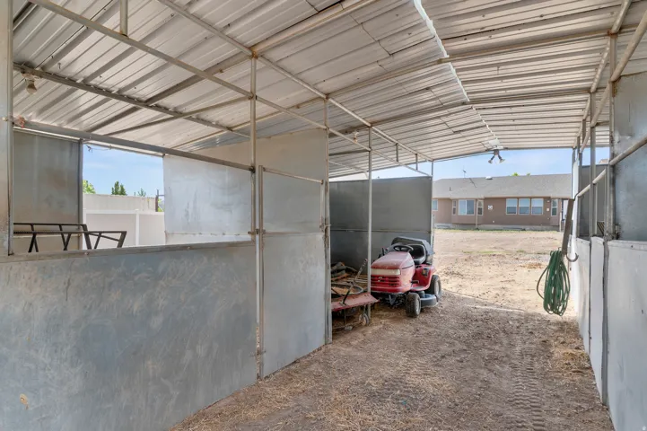 Covered metal barn structure featuring partitioned stalls and a metal roof