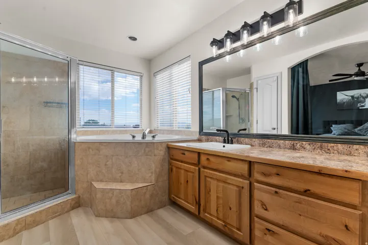 Walk-in shower with clear glass enclosure and tile surround, seperate soaking tub