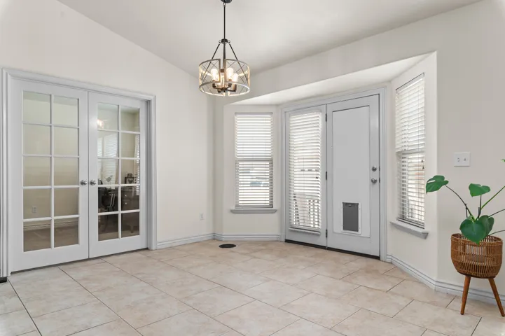 Bay window with multiple windows, glass-panel french doors, and a decorative ceiling light fixture