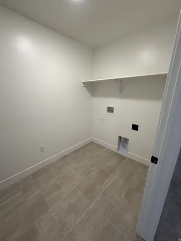 Neutral-toned tile flooring, built-in shelving, and white walls