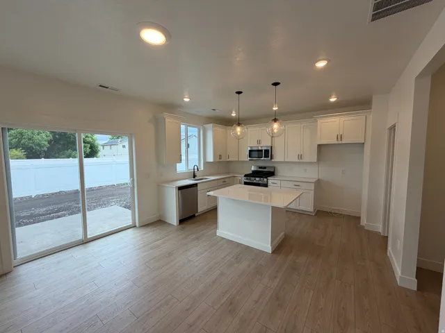 Kitchen featuring white cabinetry, stainless steel appliances, a center island with a solid surface countertop, and recessed lighting