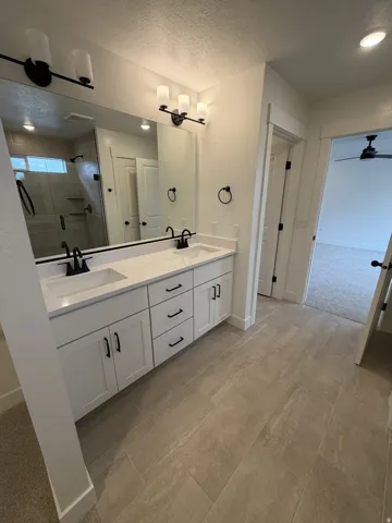 Double vanity with white cabinetry, matte black hardware, and integrated sinks