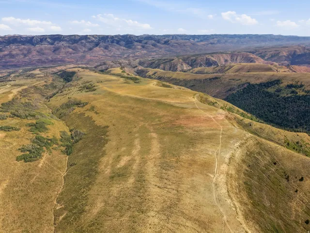 Expansive mountainous terrain with varied topography, including rolling hills and forested valleys