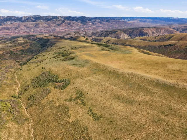 Expansive natural landscape featuring rolling hills and distant mountainous terrain