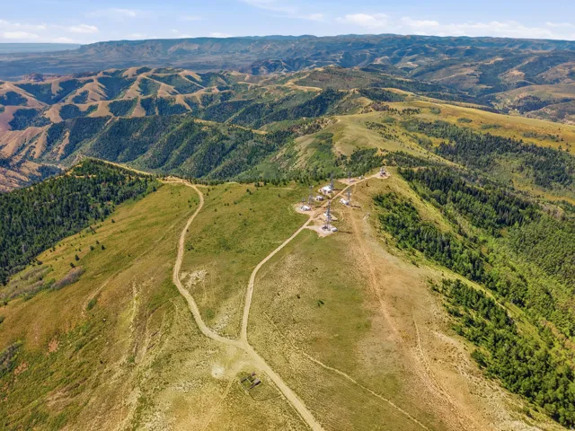 Expansive mountainous terrain with varied topography, including verdant hillsides and distant peaks