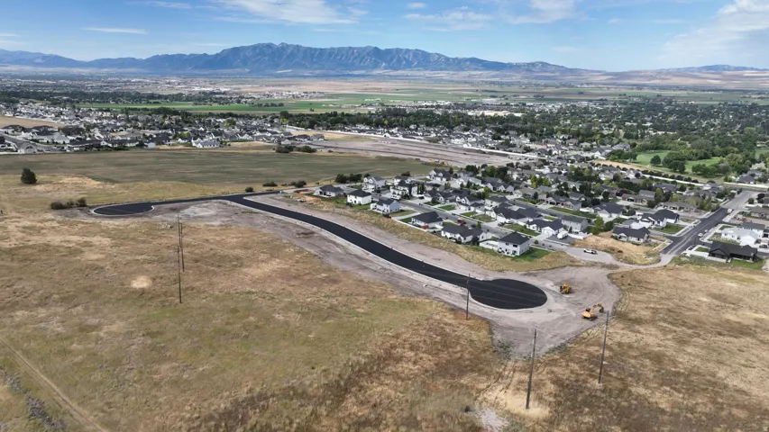 Developing residential area with newly paved cul-de-sac and mountain background