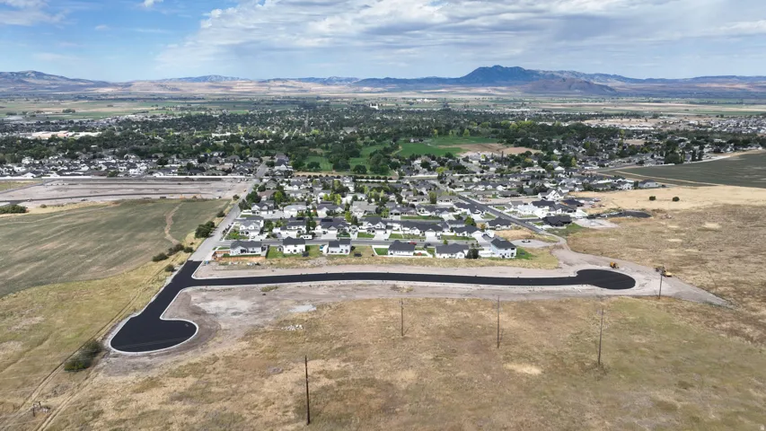 Newly paved cul-de-sac and developing residential area with distant mountains