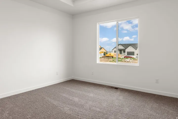 Recessed ceiling detail, neutral carpet flooring, white walls, and a large window