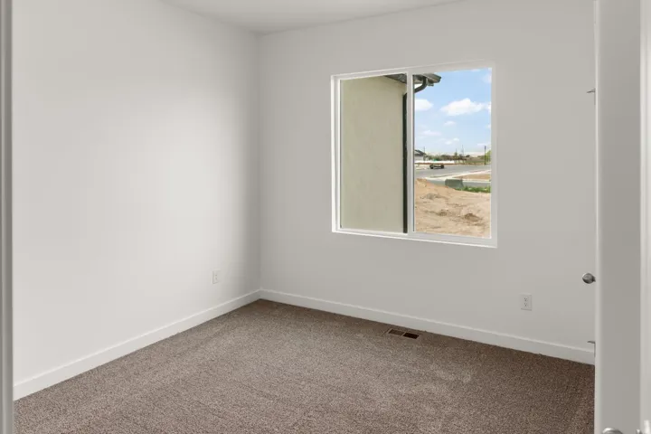 Neutral wall color, carpeted flooring, and a sliding window