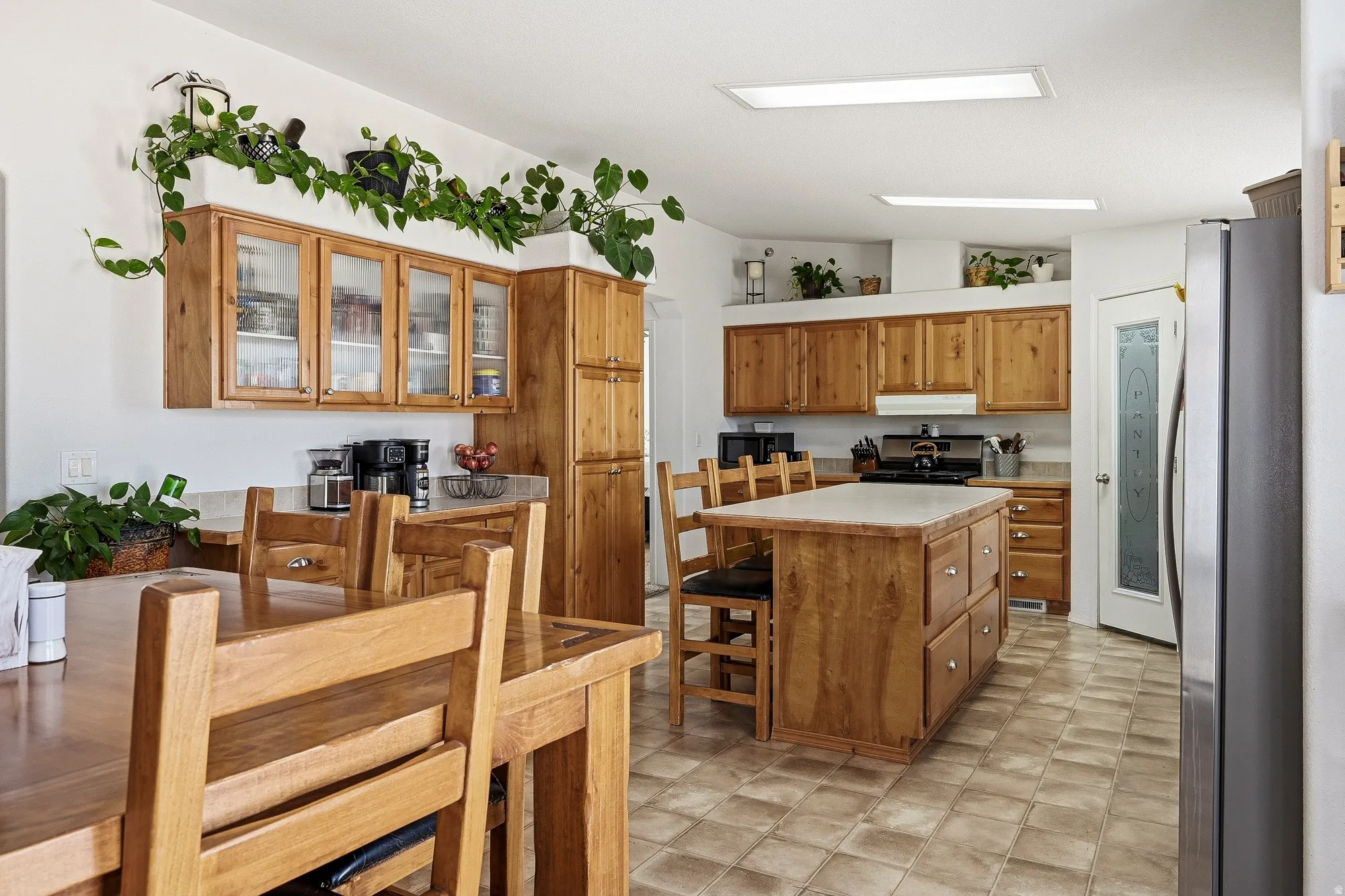 Kitchen featuring wood cabinetry, a center island with countertop, and ceramic tile flooring