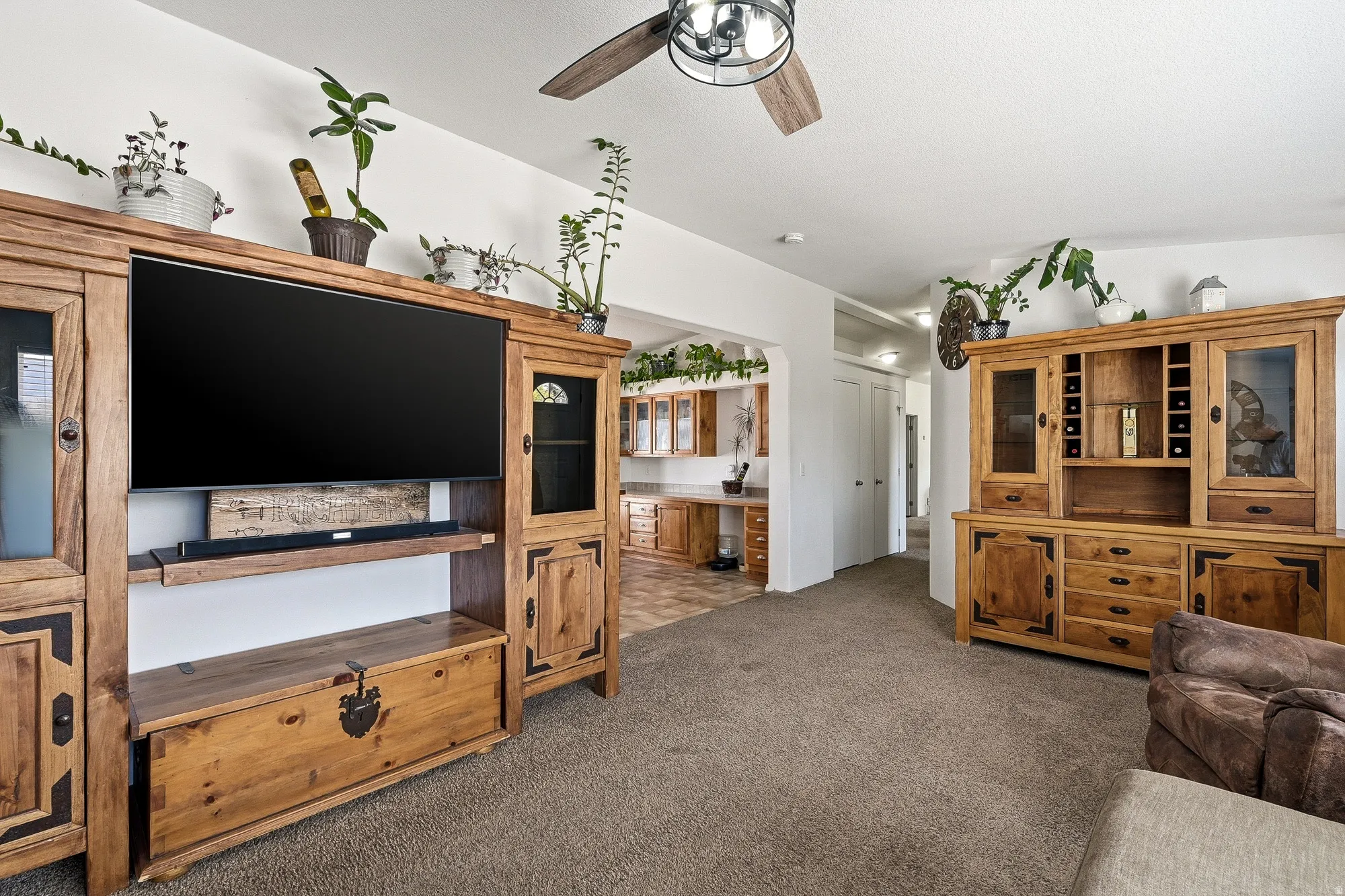 Neutral tone wall paint, wood-finish flooring, and a ceiling fan with light fixture