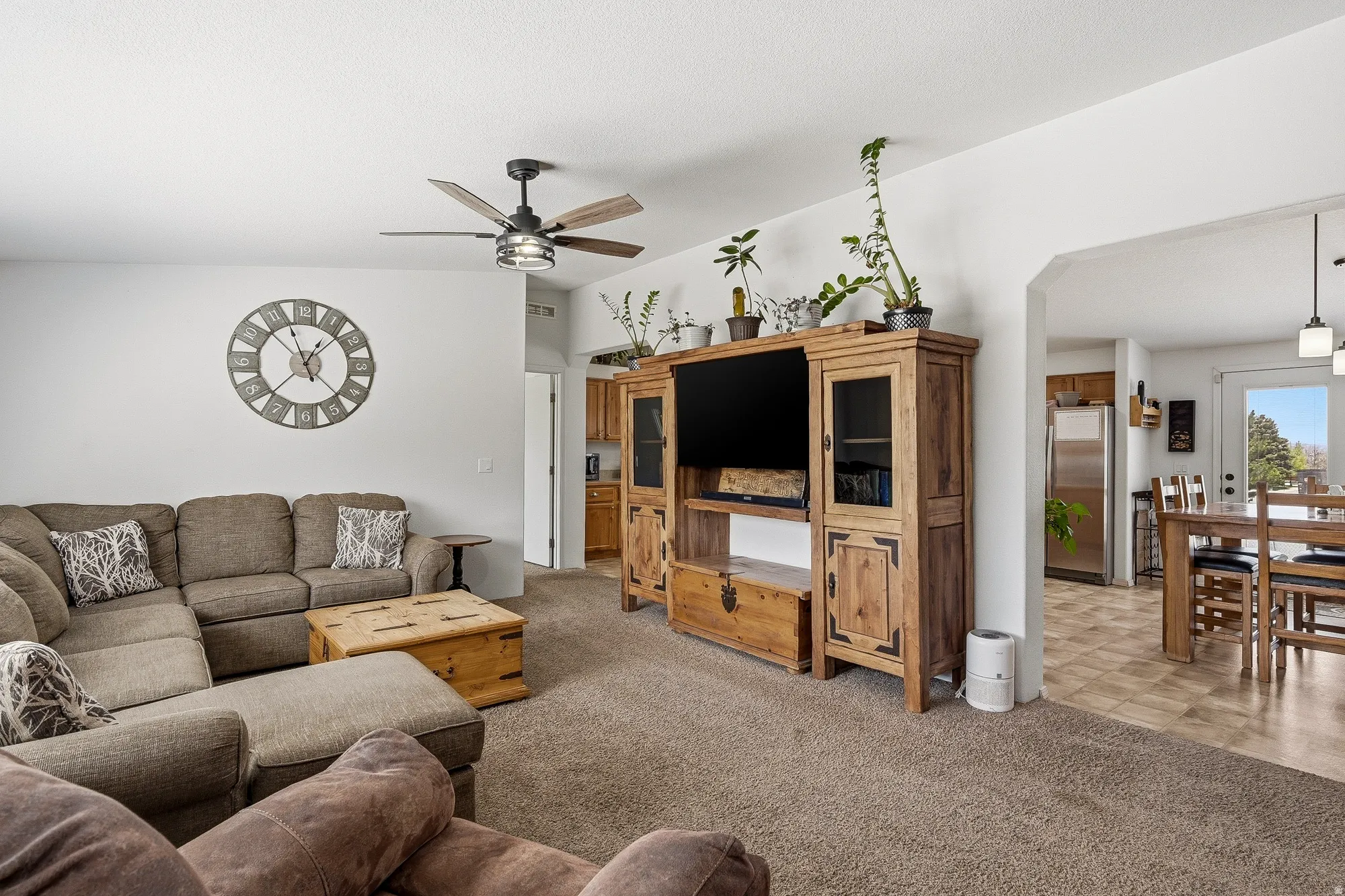 Carpeted living area with ceiling fan
