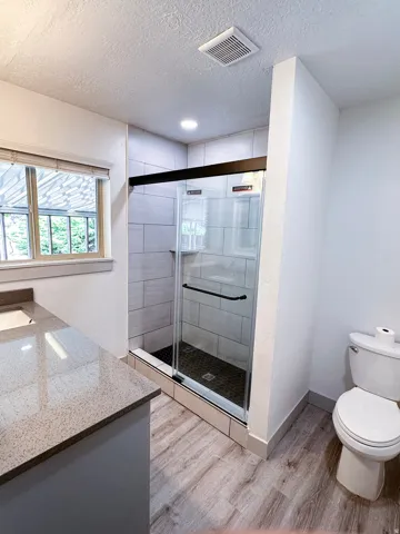 Walk-in shower with clear glass enclosure and tiled walls