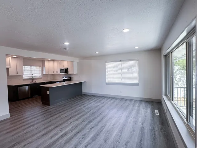 Modern kitchen with light cabinetry, stainless steel appliances, and a central island