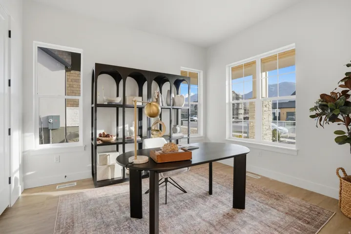 Light wood-finish flooring, white walls, and multiple windows with white trim