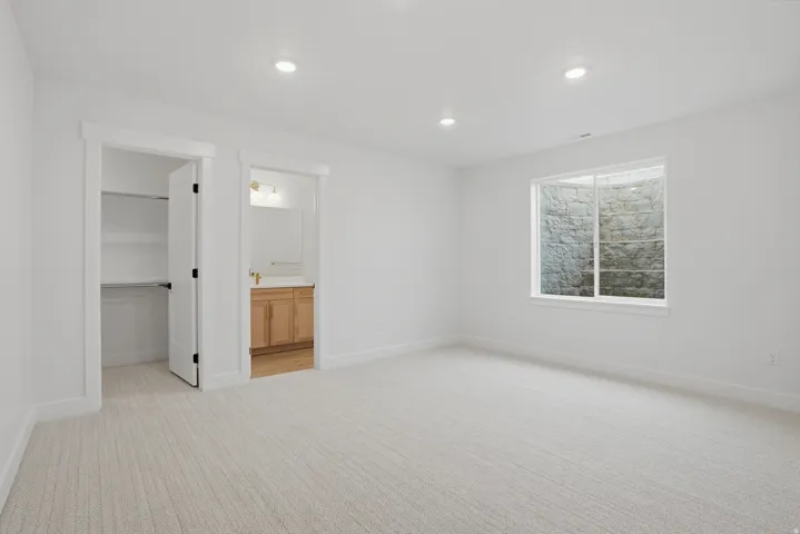 Recessed lighting, light-colored carpeting, and white walls