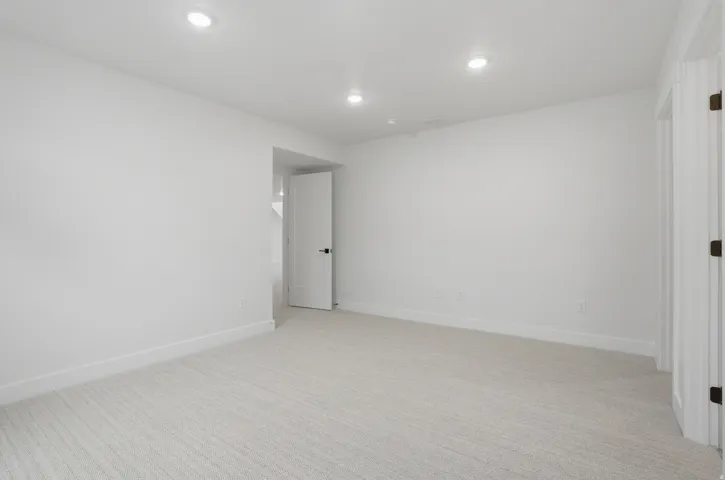 Recessed lighting, light-toned carpeting, white walls, and white trim