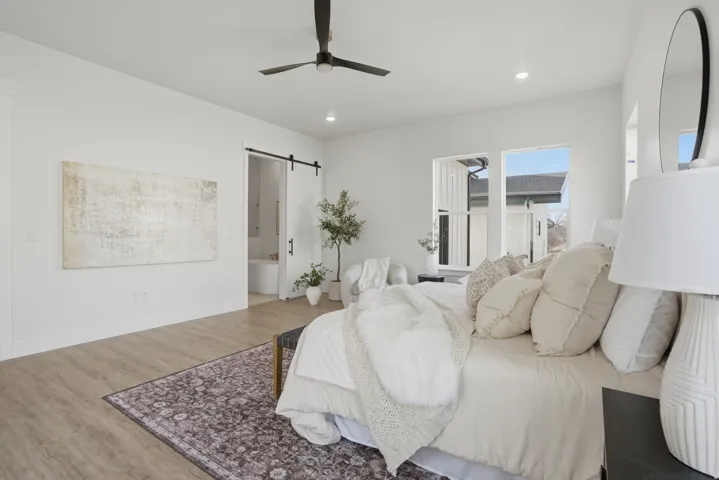Recessed lighting, wood-finish flooring, a barn door entry, and a ceiling fan