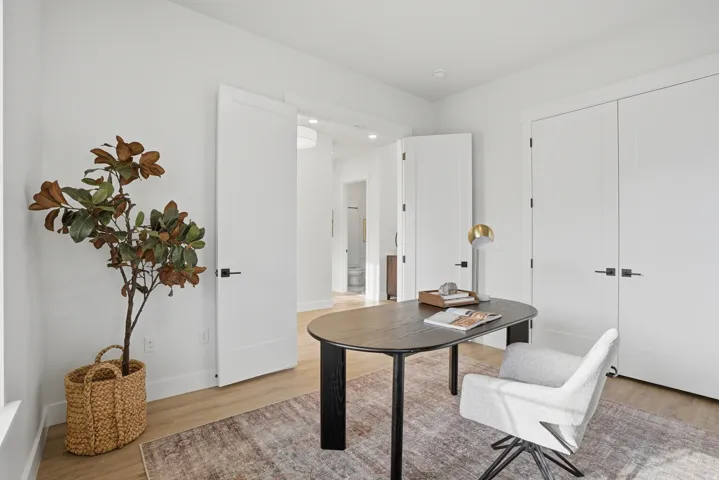 Recessed lighting, wood-finish flooring, white walls, and white doors with matte black hardware