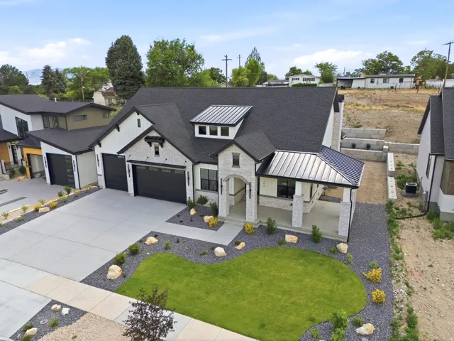 Modern farmhouse-style residence with a dark asphalt shingle roof and a metal accent roof over the covered porch