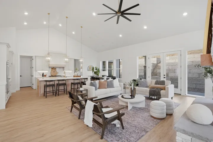 Vaulted ceilings with recessed lighting, wood-finish flooring, kitchen island with seating, built-in double ovens, and glass-paneled doors