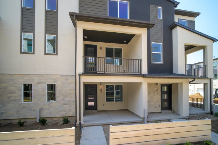 Multi-level facade with light-toned stucco and dark horizontal siding