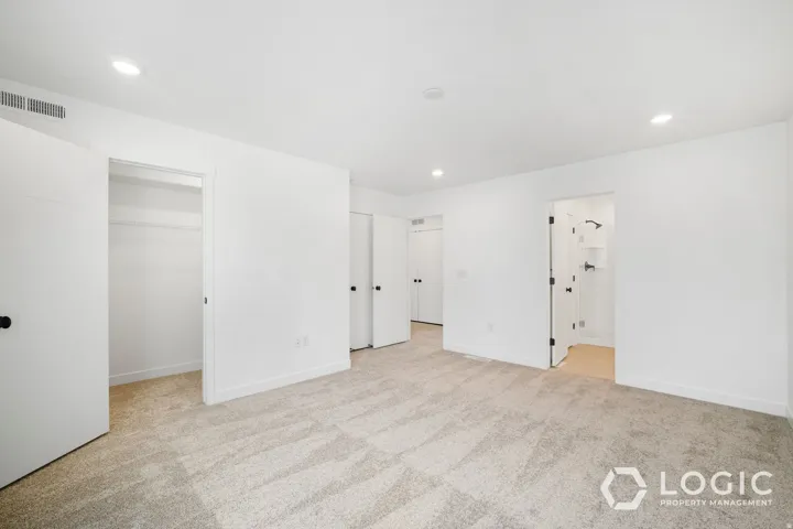 Spacious room with light-colored carpeting, recessed lighting, and white walls