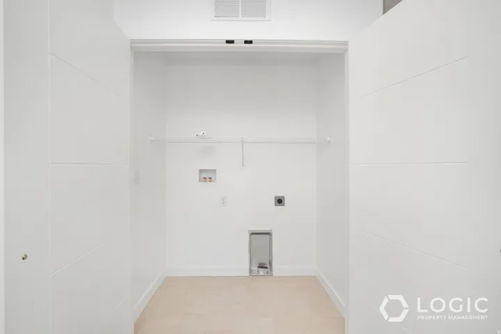 Laundry area featuring a wire shelf, white walls, and light-toned flooring