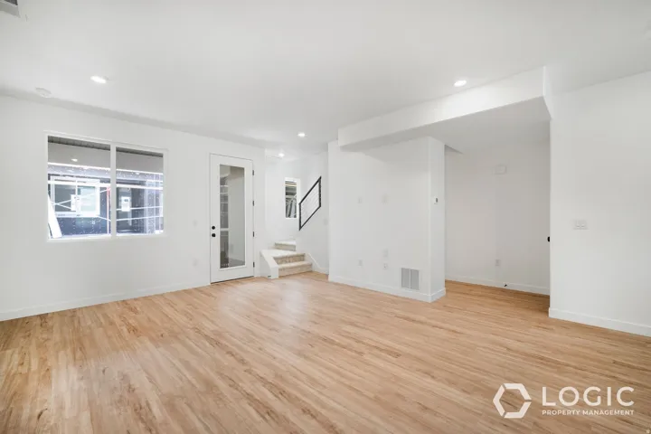 Bright interior with wood-finish flooring, recessed lighting, and a glass-paneled door