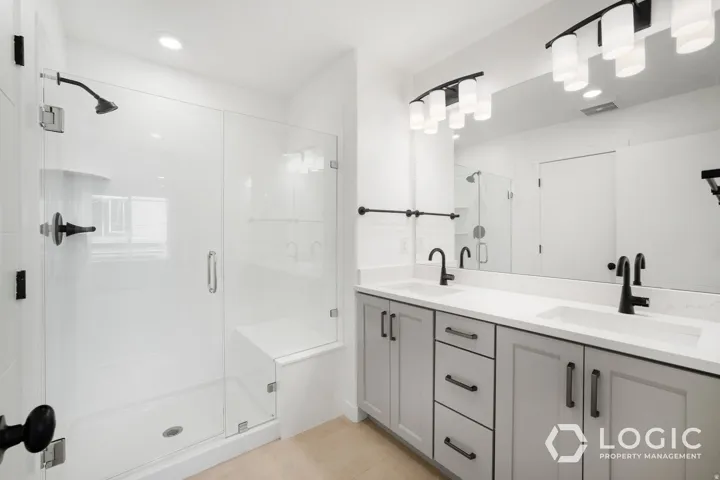 Dual vanity with quartz countertop, matte black fixtures, and framed mirror