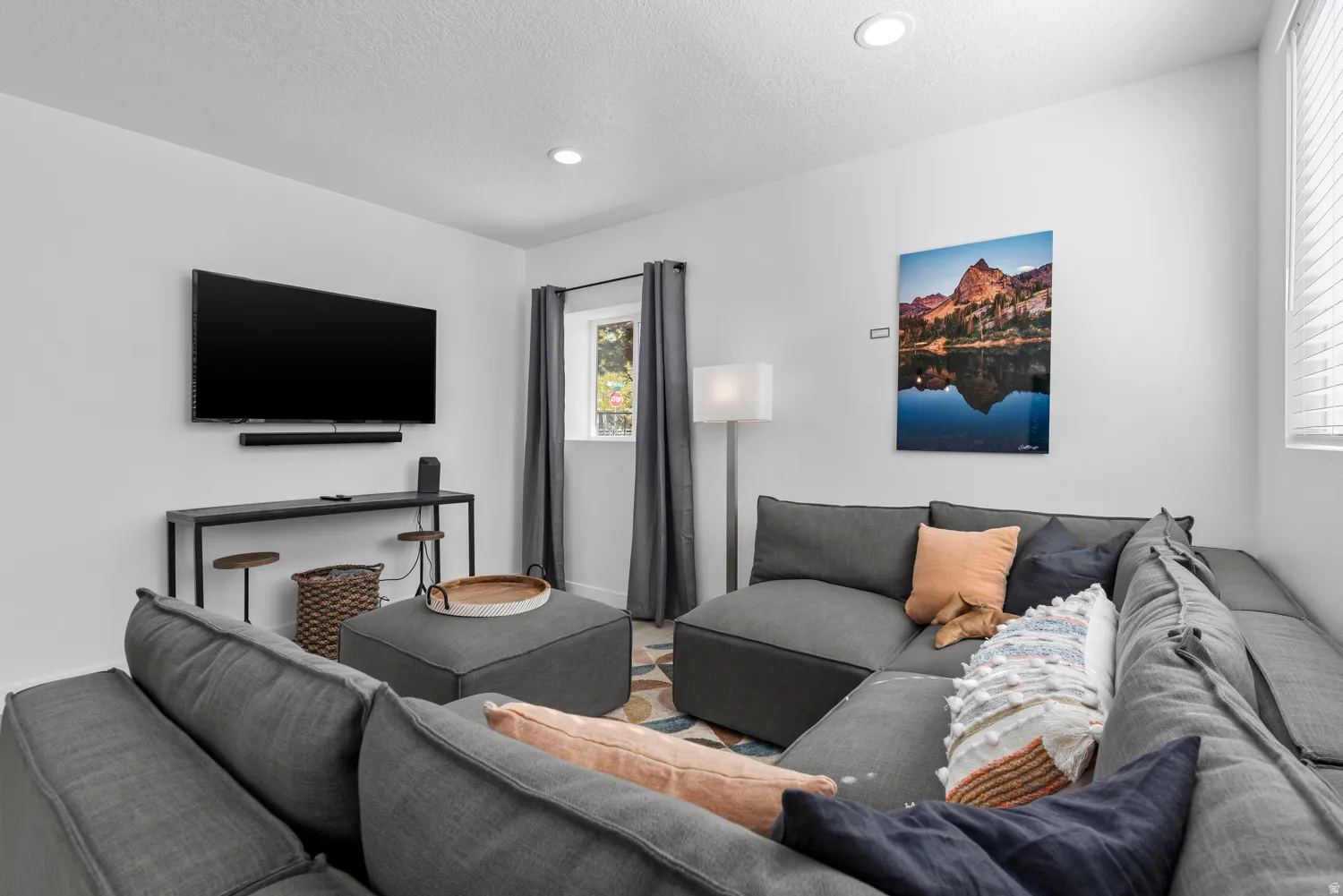 Unit #2Recessed ceiling lighting, wall-mounted television, console table, window with blinds, and drapery rods