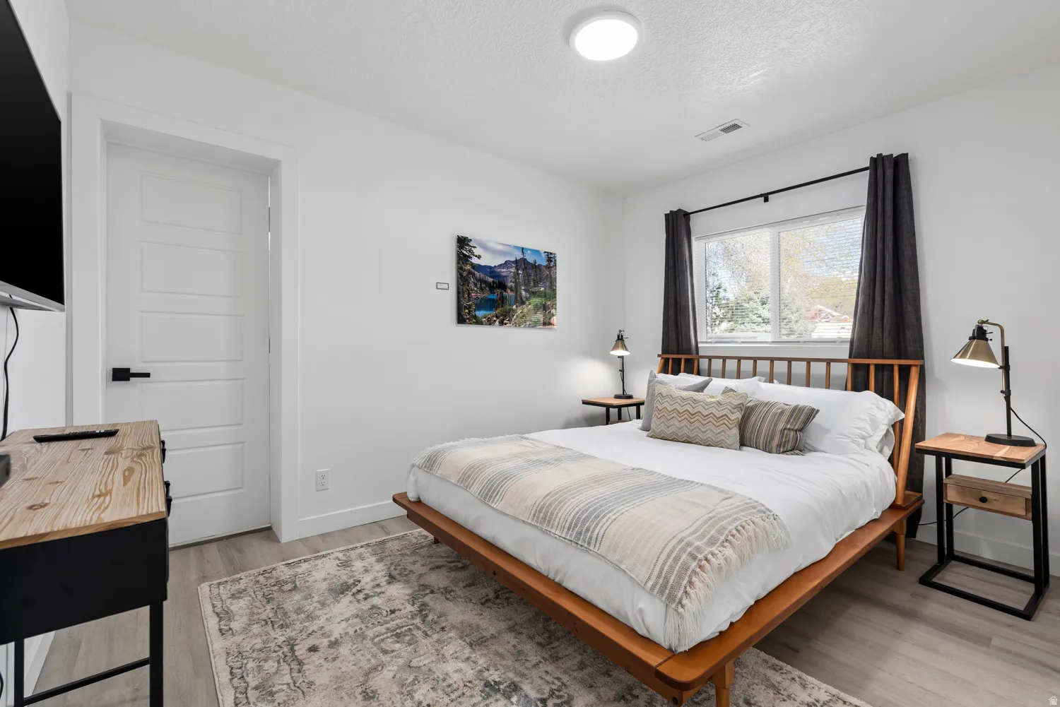 Unit #2Light wood-finish flooring with crisp white walls and a large window